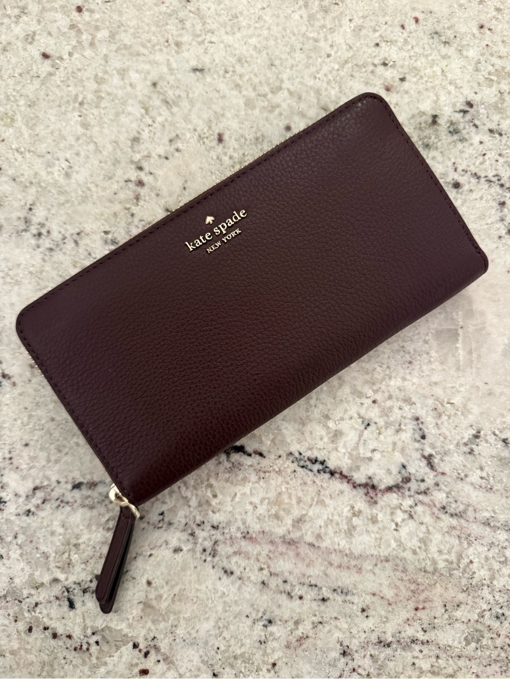 kate spade pebbled leather zip-around wallet in deep burgundy with gold hardware